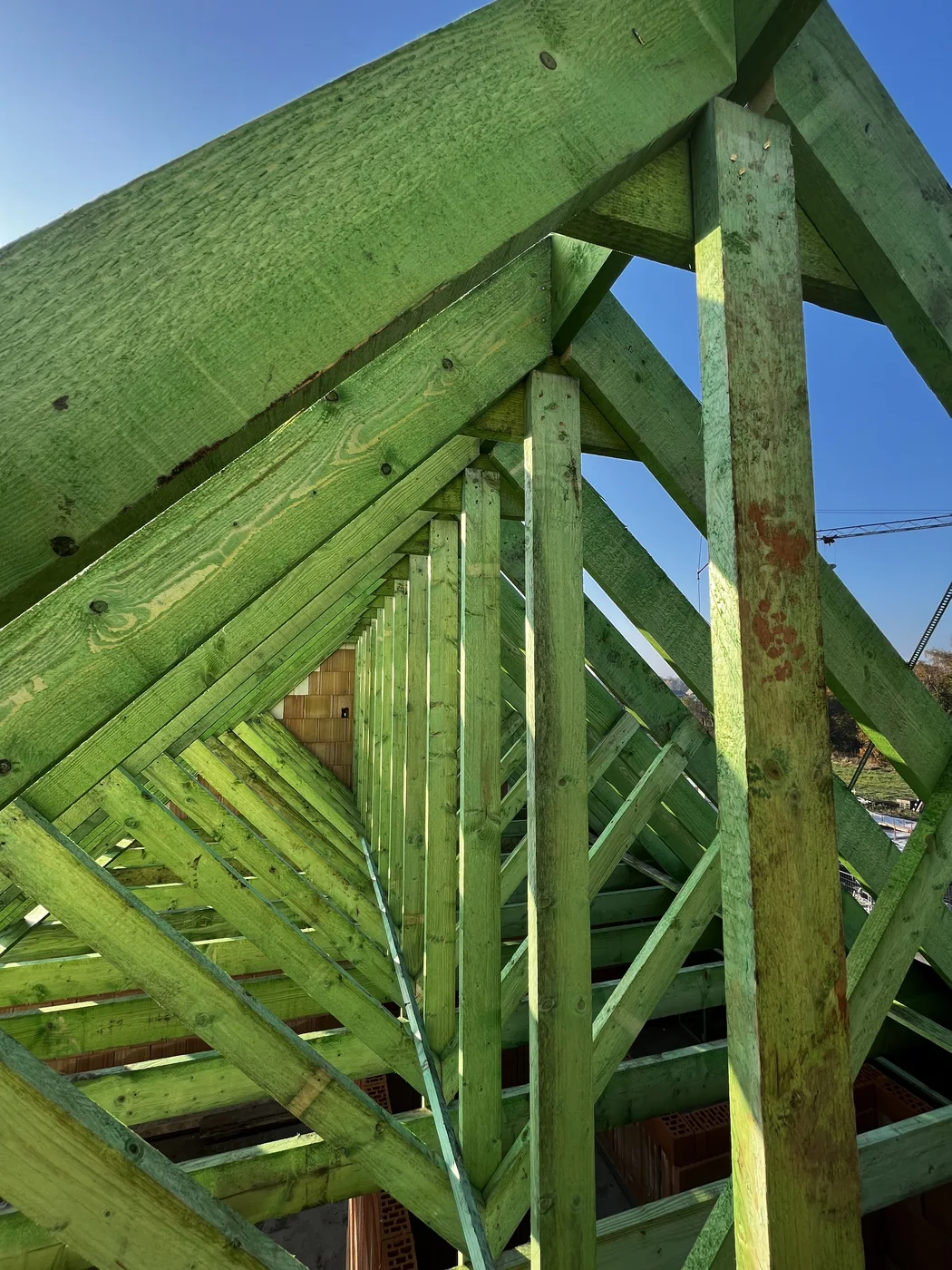 Detail van groene houten balken in een dakconstructie
