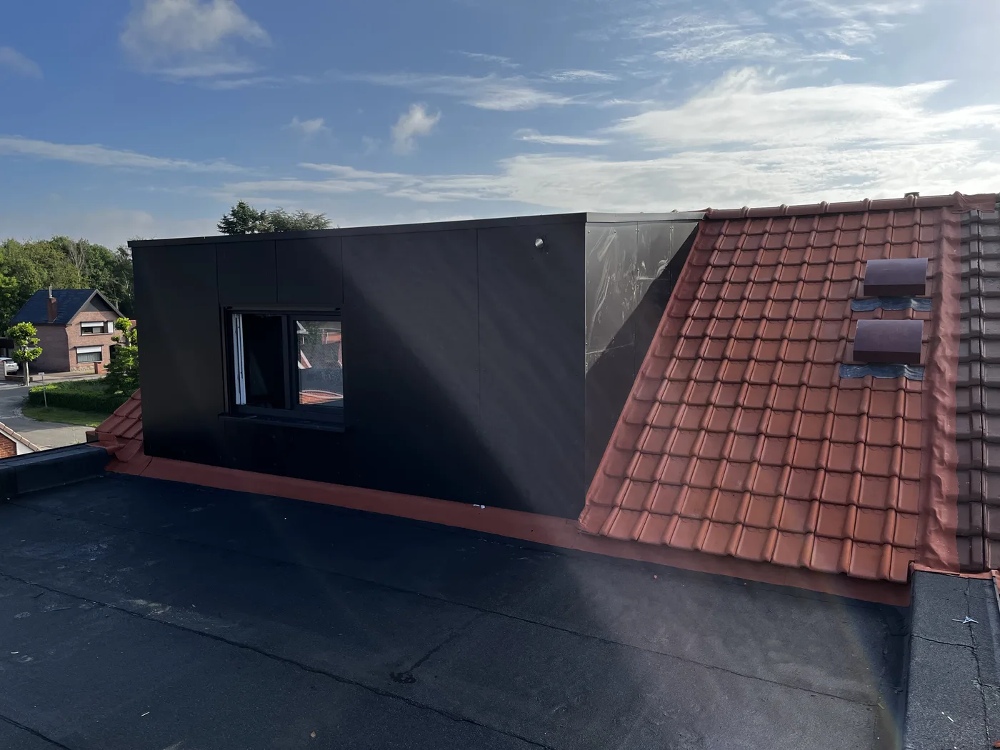Dakkapel in trespa naast een rood pannendak en een plat dak in epdm