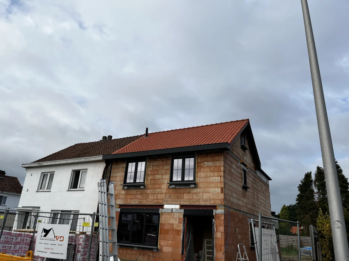 Rood pannendak op een woning met bakstenen en witte gevel