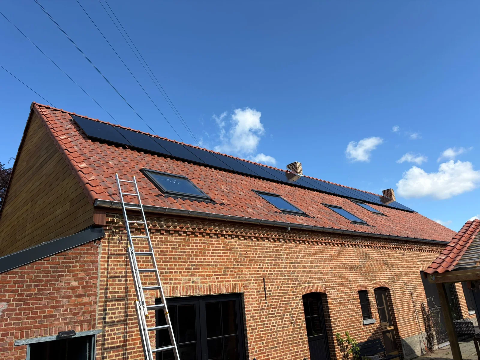 Hellend pannendak met zonnepanelen en dakramen