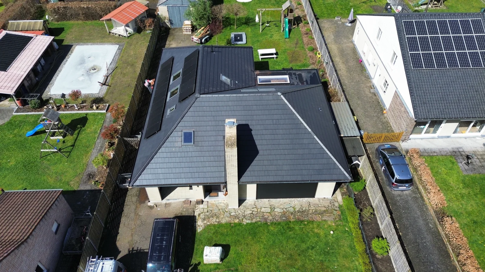 Dak met dakramen en zonnepanelen gezien vanuit de lucht